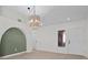 Open-concept living area with modern lighting, arched doorway, and view into the kitchen and entryway at 2216 Spring Water Dr, Las Vegas, NV 89134