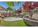 Lush backyard features a charming stone patio, red maple trees, and desert landscaping at 2621 Icy Moon St, Henderson, NV 89044