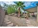 Private backyard featuring a stone patio, mature trees, and desert landscaping at 2621 Icy Moon St, Henderson, NV 89044