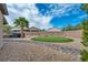 Landscaped backyard with a putting green, hot tub, palm trees, and desert landscaping at 2621 Icy Moon St, Henderson, NV 89044