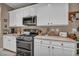 Kitchen with white cabinets, light countertops, and stainless steel appliances at 2621 Icy Moon St, Henderson, NV 89044