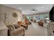 Open-concept living room featuring plush seating, a ceiling fan, and natural light from the windows at 2621 Icy Moon St, Henderson, NV 89044