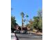 View of the gated community entrance with mature trees and lush landscaping, offering privacy and curb appeal at 4050 Pacific Harbors Dr # 149, Las Vegas, NV 89121