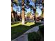 Community pool area with green grass and mature trees at 4050 Pacific Harbors Dr # 149, Las Vegas, NV 89121