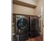 Modern laundry room featuring front-load washer and dryer on pedestals at 4609 Hearts Desire Ave, Las Vegas, NV 89115