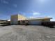 View of a tan house with a garage and gravel driveway and desert landscape at 4831 W Bell Vista Ave, Pahrump, NV 89060