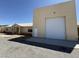 View of house with a white door and a large garage attached to the right at 4831 W Bell Vista Ave, Pahrump, NV 89060