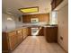 Kitchen featuring tile floors, wooden cabinets, and white appliances at 4831 W Bell Vista Ave, Pahrump, NV 89060