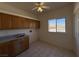 Laundry room with a utility sink, wooden cabinets, and tiled floors at 4831 W Bell Vista Ave, Pahrump, NV 89060