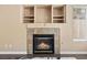 Living room fireplace with decorative tile surround and built-in shelves, adding character and storage at 5 Spur Cross Cir, Henderson, NV 89012