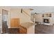 Open-concept living room featuring a cozy fireplace and staircase access to the second floor at 5 Spur Cross Cir, Henderson, NV 89012