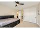 Bedroom with neutral walls and carpet has a ceiling fan, closet, and en-suite bathroom at 5879 Sky Heights Ct, Las Vegas, NV 89135