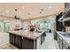 Modern kitchen features a spacious island, stainless steel appliances, and an open layout flowing into the living room at 5879 Sky Heights Ct, Las Vegas, NV 89135