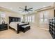 This is a main bedroom featuring a dark wood bedroom set, beige walls and carpet, and plantation shutters at 5879 Sky Heights Ct, Las Vegas, NV 89135