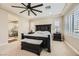 A main bedroom showing a dark wood bedroom set, beige walls and carpet, and an ensuite bathroom with a glass shower at 5879 Sky Heights Ct, Las Vegas, NV 89135