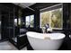Modern bathroom featuring a freestanding tub, black marble accents, and a glass enclosed shower at 6101 Browning Way, Las Vegas, NV 89130