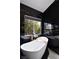Luxurious bathroom featuring a freestanding tub, black marble accents, and a window at 6101 Browning Way, Las Vegas, NV 89130