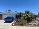 Charming single-story home featuring a desert landscape, blue car, and solar panels on the roof at 6432 Aberdeen Ln, Las Vegas, NV 89107