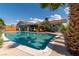 Inviting pool with a mature palm tree in the spacious backyard under a beautiful blue sky, perfect for outdoor enjoyment at 6432 Aberdeen Ln, Las Vegas, NV 89107