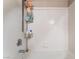 Bright white tiled bathtub and shower combo with a storage rack at 6955 N Durango Dr # 3013, Las Vegas, NV 89149