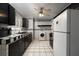 Traditional-style kitchen with checkerboard backsplash, black cabinets and complete with appliances at 704 Kings Ave, North Las Vegas, NV 89030