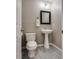 A clean powder room with a pedestal sink, toilet, and neutral wall color at 9112 Canoga Canyon Ct # 103, Las Vegas, NV 89149
