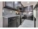 Updated kitchen featuring granite countertops, modern appliances, and stylish dark cabinetry at 9112 Canoga Canyon Ct # 103, Las Vegas, NV 89149