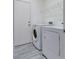 Functional laundry room with modern washer and dryer, storage shelf, and tile flooring at 9112 Canoga Canyon Ct # 103, Las Vegas, NV 89149
