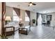 Spacious living room with a ceiling fan, gray-toned floor tiles, and modern decor with view into the dining area at 9112 Canoga Canyon Ct # 103, Las Vegas, NV 89149