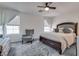 Spacious main bedroom with a ceiling fan, chair and two windows for natural light at 9112 Canoga Canyon Ct # 103, Las Vegas, NV 89149