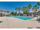 Community pool area surrounded by palm trees and lounge chairs on a sunny day at 9112 Canoga Canyon Ct # 103, Las Vegas, NV 89149