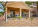 Staged backyard patio featuring comfortable seating and a landscaped area with mature tree at 10646 Heritage Hills Dr, Las Vegas, NV 89134