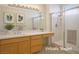 Bright bathroom featuring a long vanity, shower with glass doors, and sleek fixtures at 10646 Heritage Hills Dr, Las Vegas, NV 89134