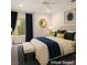 Inviting staged bedroom featuring a queen bed, blue accents, and a view to the outside at 10646 Heritage Hills Dr, Las Vegas, NV 89134