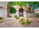 Inviting front yard featuring decorative rock landscaping, mature tree, and secure entry gate at 10646 Heritage Hills Dr, Las Vegas, NV 89134