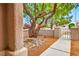 Landscaped front yard featuring decorative rock, mature tree, walkway, and secure gate at 10646 Heritage Hills Dr, Las Vegas, NV 89134