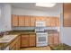 Well-lit kitchen featuring granite countertops, wood cabinets, and modern white appliances for a clean aesthetic at 10646 Heritage Hills Dr, Las Vegas, NV 89134