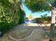 Landscaped backyard featuring mature trees, bushes, brick-lined planting beds and ample space for outdoor activities at 10719 Hammett Park Ave, Las Vegas, NV 89166