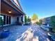Outdoor covered patio with brick pavers, outdoor kitchen area, and partial landscaping at 10719 Hammett Park Ave, Las Vegas, NV 89166