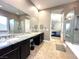 Bathroom featuring a double vanity, soaking tub, and glass-enclosed shower at 10719 Hammett Park Ave, Las Vegas, NV 89166