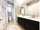 Bathroom with double sinks, modern vanity, and tiled floors, ensuring comfort and style at 10719 Hammett Park Ave, Las Vegas, NV 89166