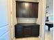 Hallway cabinet with dark brown cabinets, countertops, and neutral tile flooring at 10719 Hammett Park Ave, Las Vegas, NV 89166