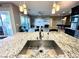 Open concept kitchen featuring a large sink, granite countertops, and modern pendant lighting at 10719 Hammett Park Ave, Las Vegas, NV 89166