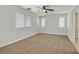 Spacious bedroom with neutral walls, carpet floors, ceiling fan and plenty of natural light from the multiple windows at 1109 Claire Rose Ave, Las Vegas, NV 89183