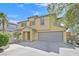 Two-story tan home featuring a tile roof, two car garage, and xeriscaping at 1109 Claire Rose Ave, Las Vegas, NV 89183