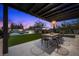 Backyard with dining area, manicured lawn and a built-in barbecue for outdoor living at 12637 Penfield Ave, Las Vegas, NV 89138
