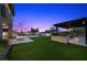 Spacious backyard featuring a pool, lounge area, kitchen, and artificial grass at 12637 Penfield Ave, Las Vegas, NV 89138