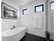 Modern bathroom featuring a freestanding tub, stylish black hardware, and sleek black and white accents at 12637 Penfield Ave, Las Vegas, NV 89138
