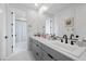 Bright bathroom featuring double sinks, modern gray cabinetry, and stylish white tile flooring at 12637 Penfield Ave, Las Vegas, NV 89138