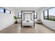 An airy bedroom with a four-poster bed, hardwood floors, and views of the mountains at 12637 Penfield Ave, Las Vegas, NV 89138